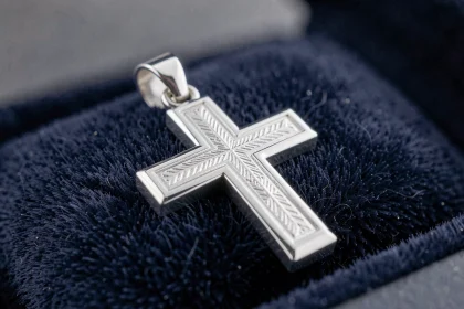 Pendentif croix en argent sterling posé sur velours bleu marine pour bijou homme de cérémonie religieuse